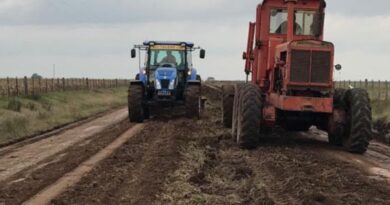 Máquina y tractor trabajando en mejoramiento de caminos rurales.