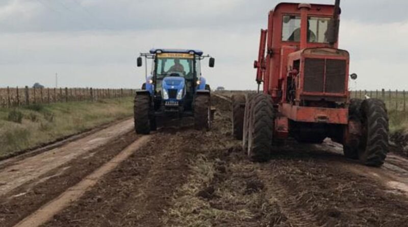 Máquina y tractor trabajando en mejoramiento de caminos rurales.