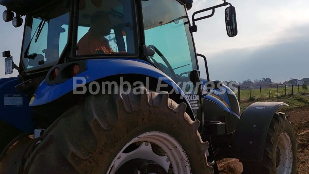 Javier Forneris manejando el tractor, en camino rural de Bombal.