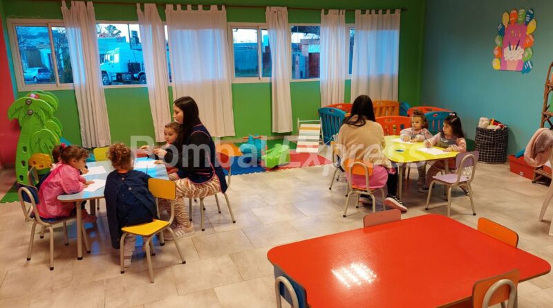 Dos docentes y niños, trabajando durante una visita a Huellitas de Amor, jardín maternal.