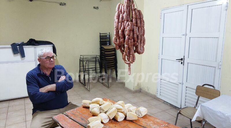 Un hombre pensativo, con los brazos cruzados, frente a una mesa con panes.