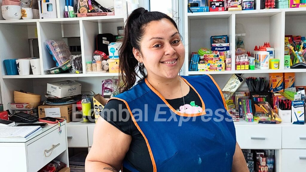 Karen sonríe en su trabajo, en el mostrador del maxiquiosco.