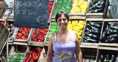 Marisa sonríe en la Verdulería de Manuel, en Alcorta, delante de cajones con coloridas verduras.