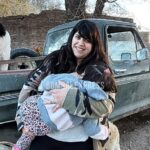 Antonella disfruta en el campo, con su pequeña hija que duerme en sus brazos.