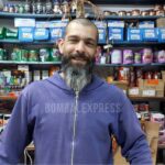 Emiliano, en la ferretería, con buzo violeta.