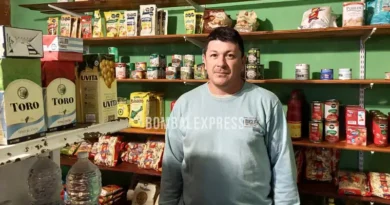 Cristian está parado entre las góndolas del negocio de Leo.