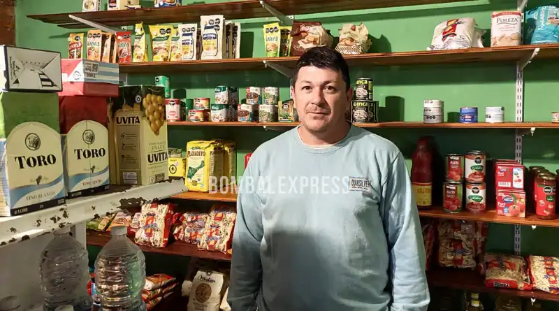 Cristian está parado entre las góndolas del negocio de Leo.