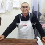 Calculín, con delantal, detrás del mostrador de la carnicería.