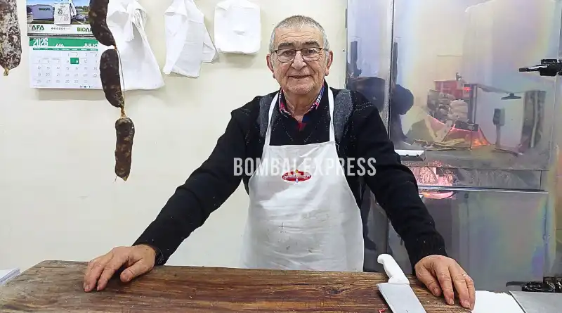 Calculín, con delantal, detrás del mostrador de la carnicería.