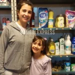 Kathy y Umma, sonrientes delante de las góndolas con productos.